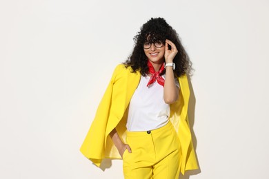 Photo of Beautiful young woman in stylish yellow suit on light background