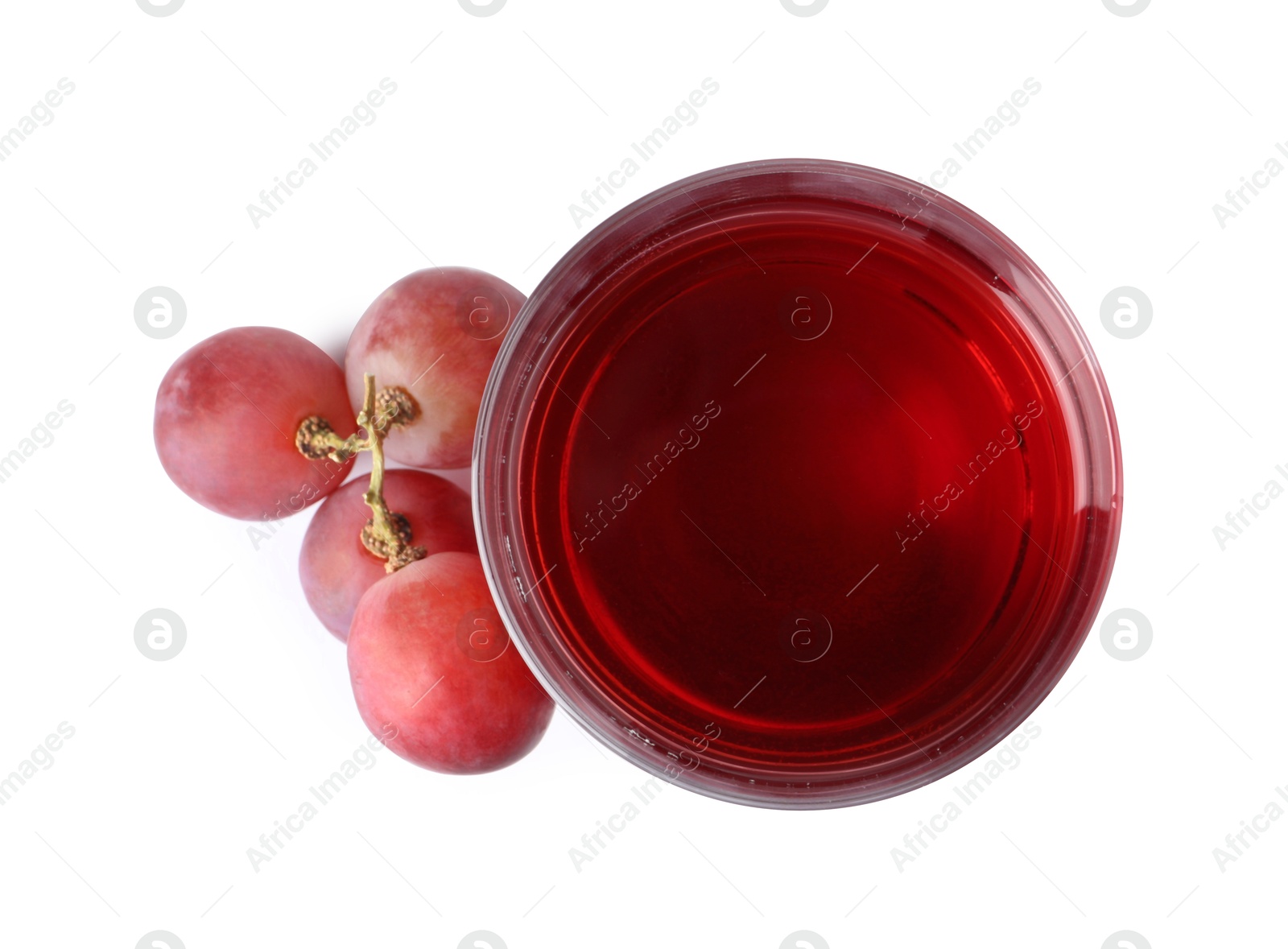 Photo of Tasty juice in glass and fresh grapes isolated on white, top view