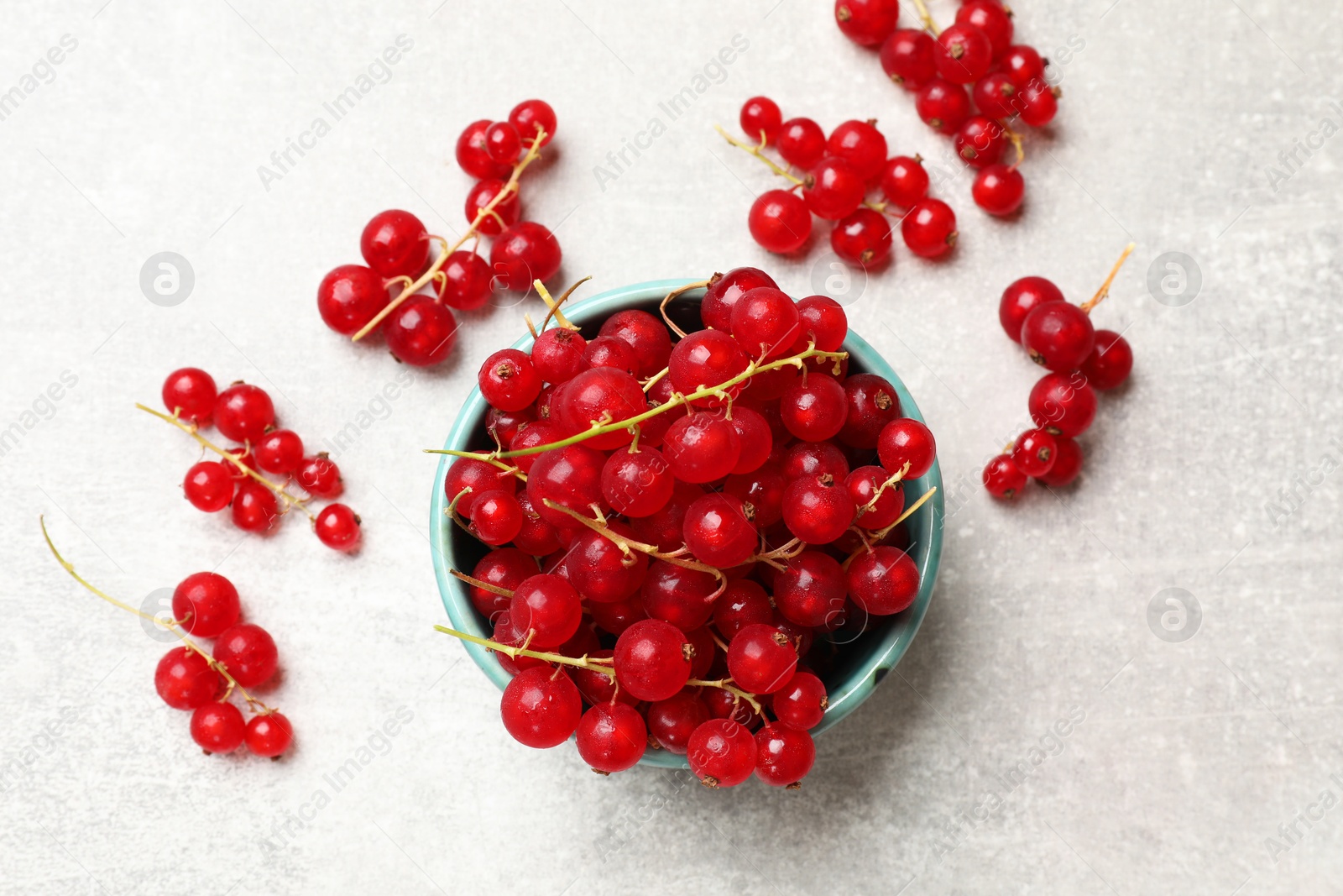 Photo of Fresh red currant in bowl on light table, top view