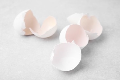 Photo of Broken eggshells on grey textured table, closeup