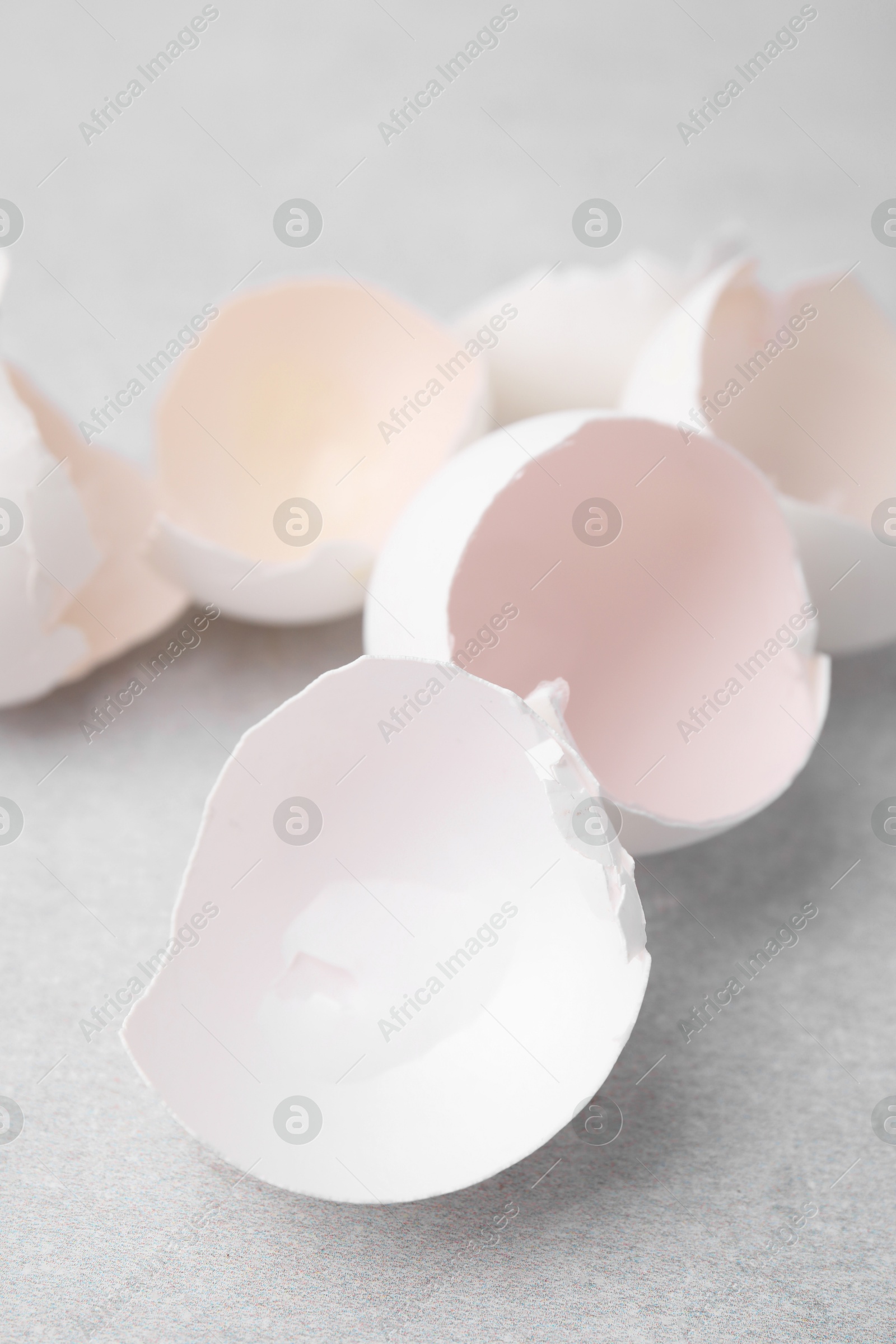 Photo of Broken eggshells on grey textured table, closeup