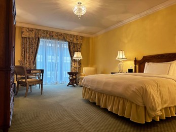 Photo of Luxury hotel interior. Comfortable large bed and modern furniture in stylish room