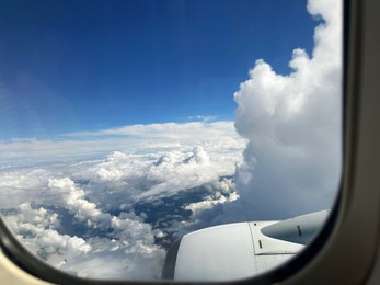 Photo of Beautiful blue sky with fluffy clouds, view from plane window