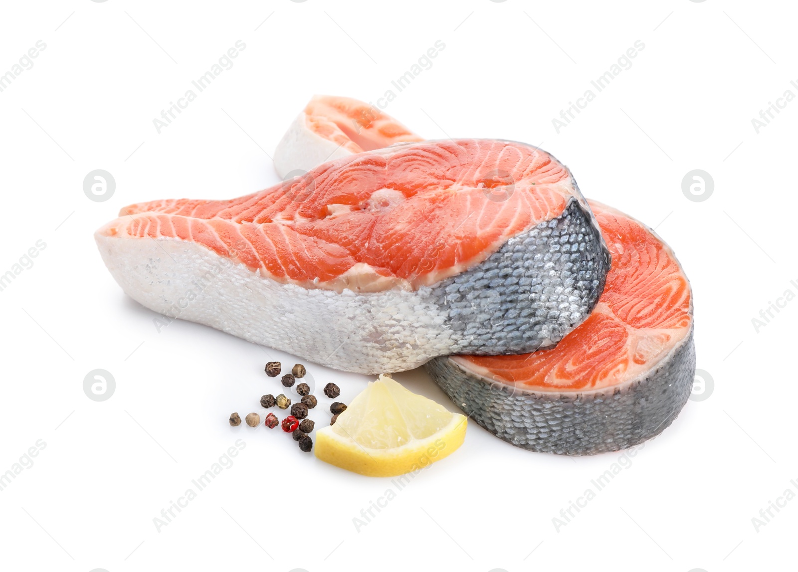 Photo of Two fresh salmon steaks, lemon and peppercorns isolated on white