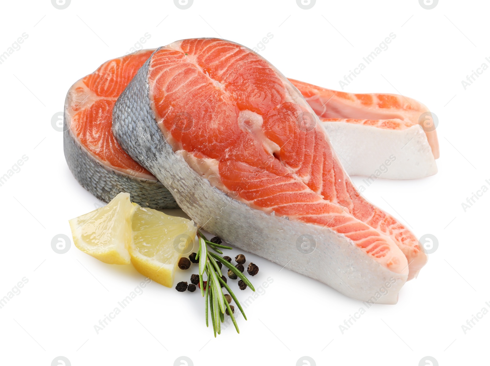 Photo of Two fresh salmon steaks, lemon, rosemary and peppercorns isolated on white