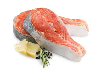 Two fresh salmon steaks, lemon, rosemary and peppercorns isolated on white