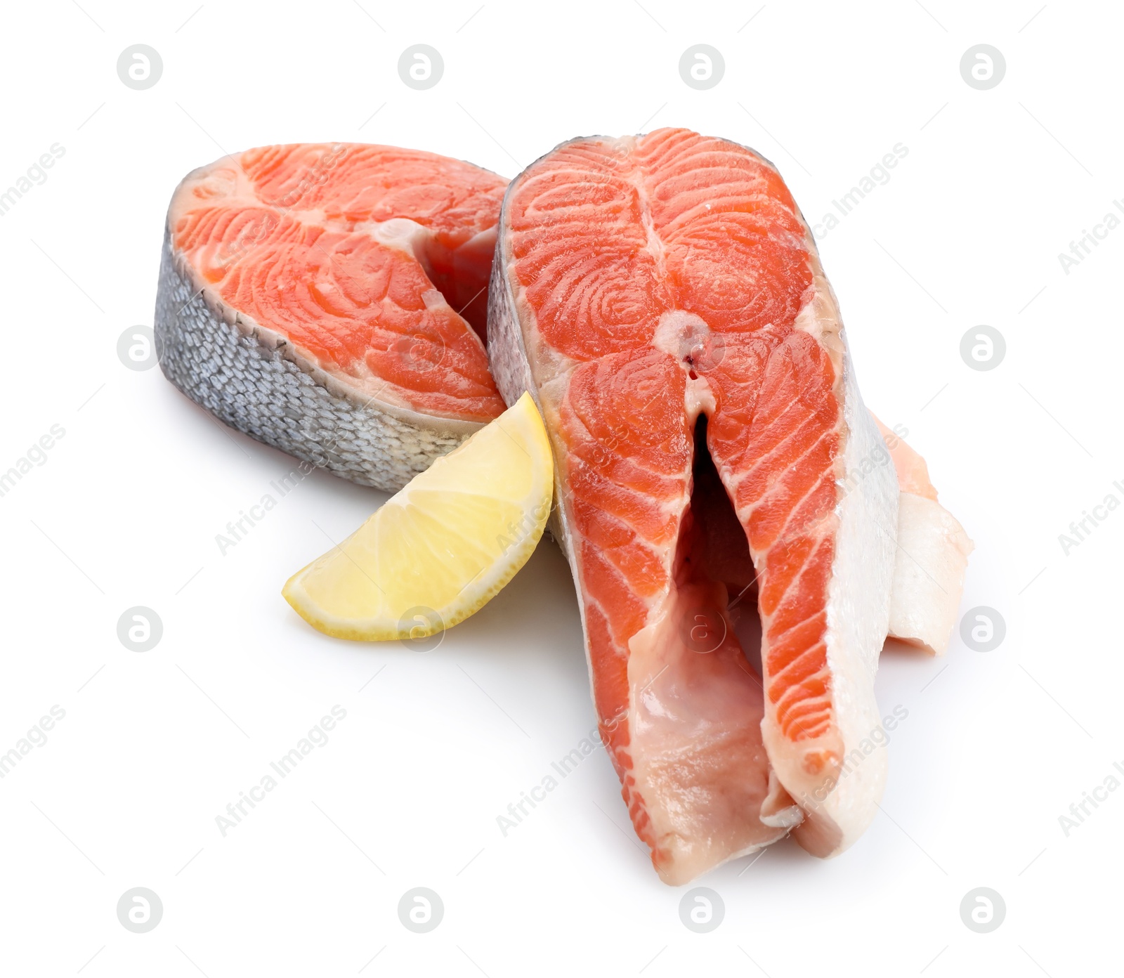 Photo of Two fresh salmon steaks and piece of lemon isolated on white