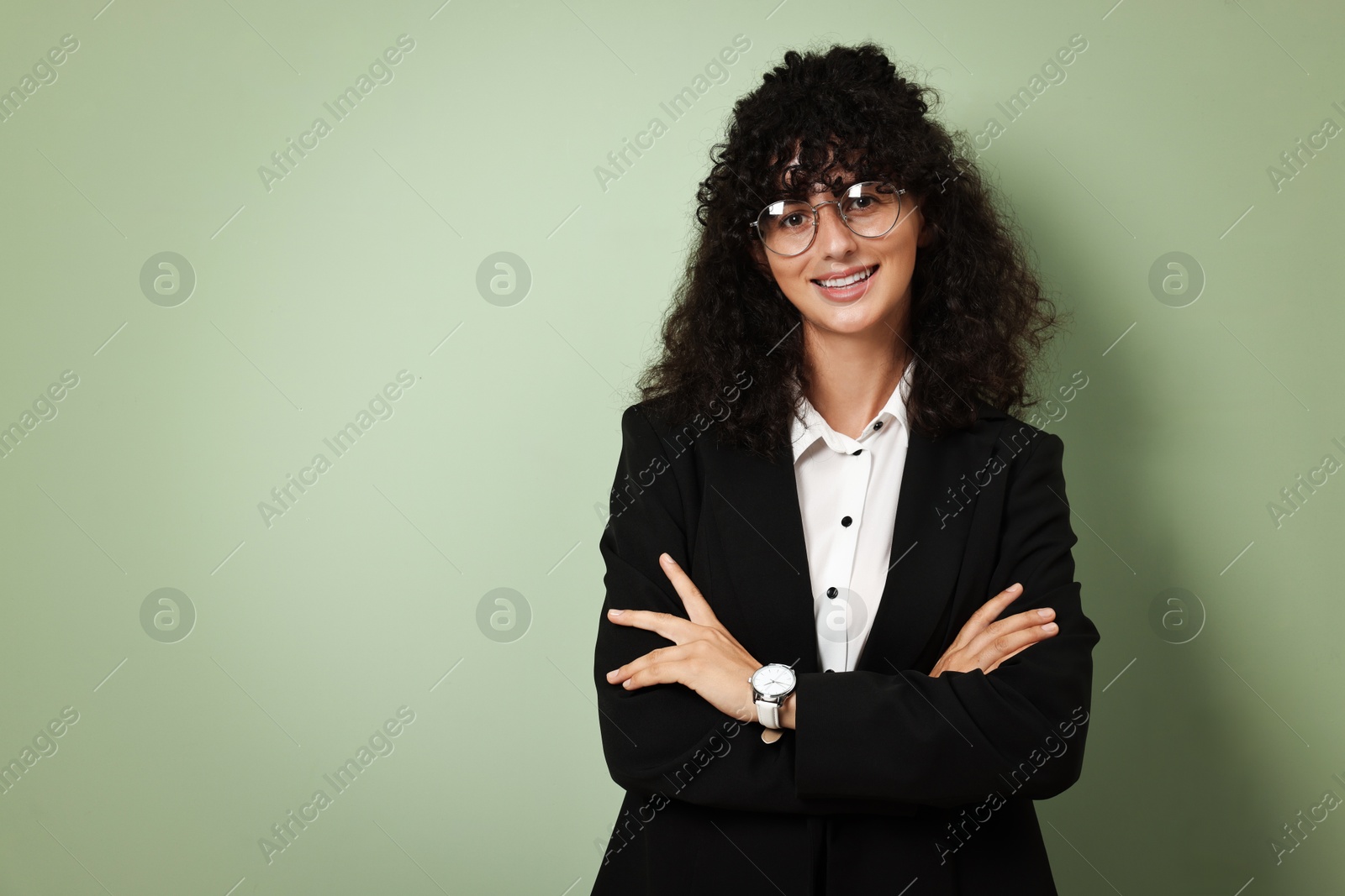 Photo of Beautiful young woman in stylish black suit on light olive background, space for text