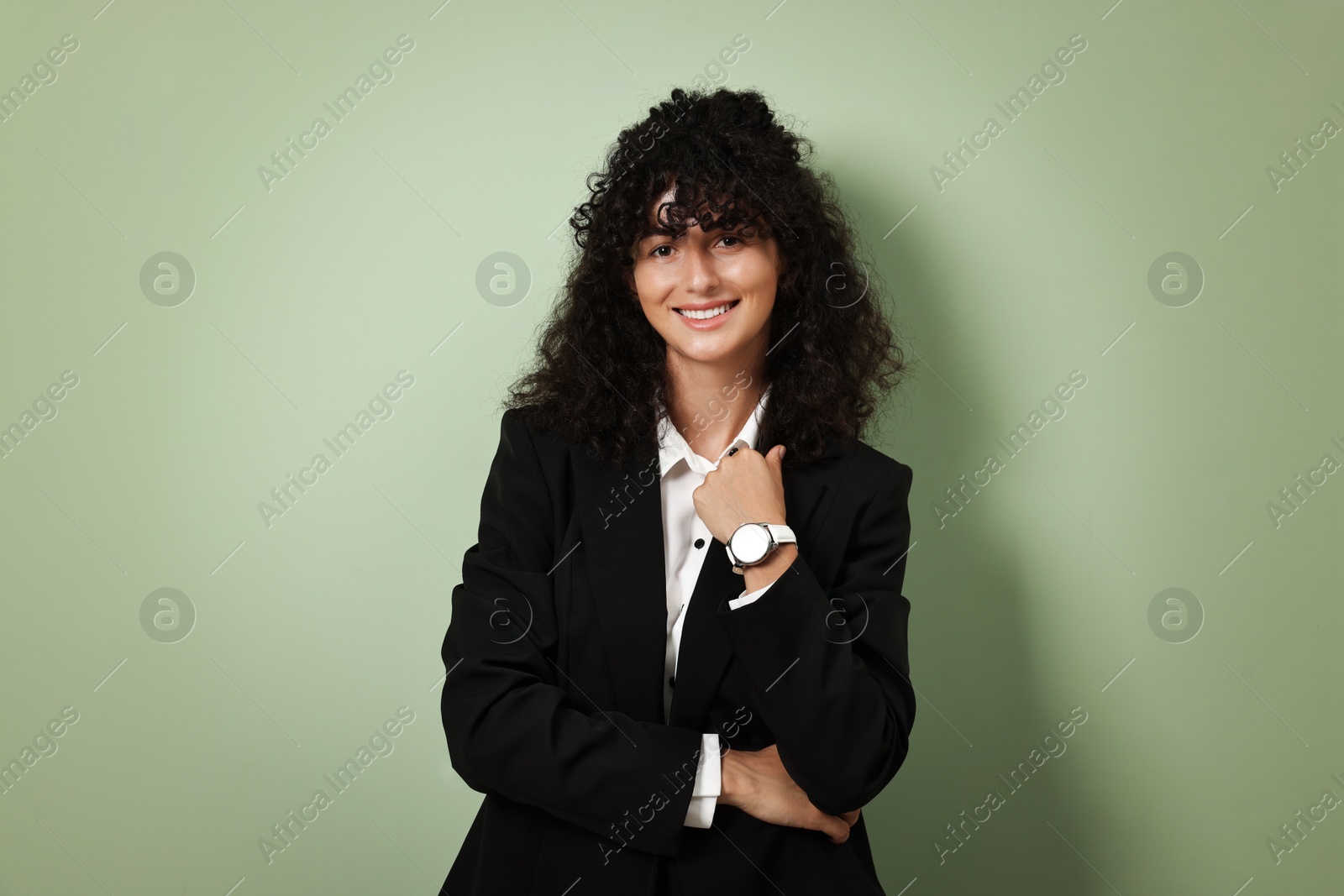 Photo of Beautiful young woman in stylish black suit on light olive background