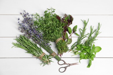 Photo of Different aromatic herbs and scissors on white wooden table, top view