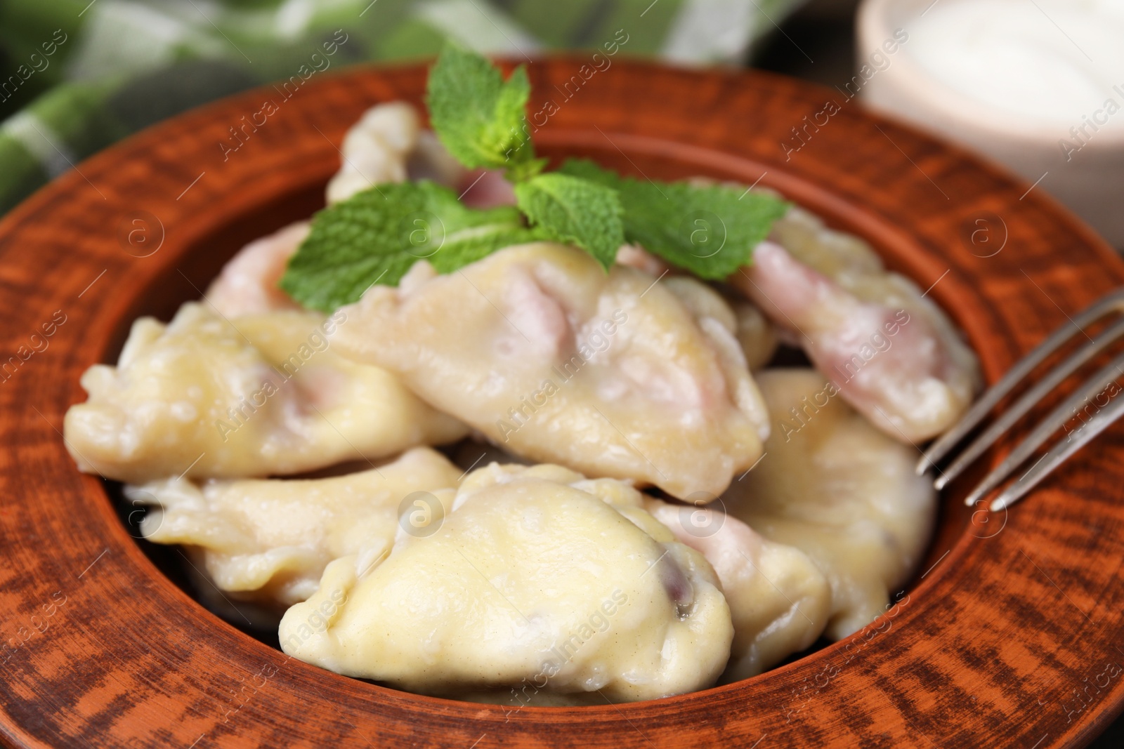 Photo of Traditional Ukrainian dumplings (varenyky) with cherries served on table, closeup