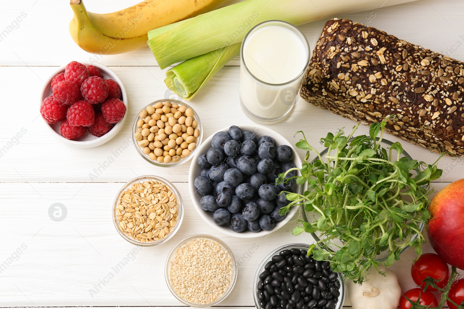 Photo of Different fresh products on white wooden table, flat lay. Source of prebiotics