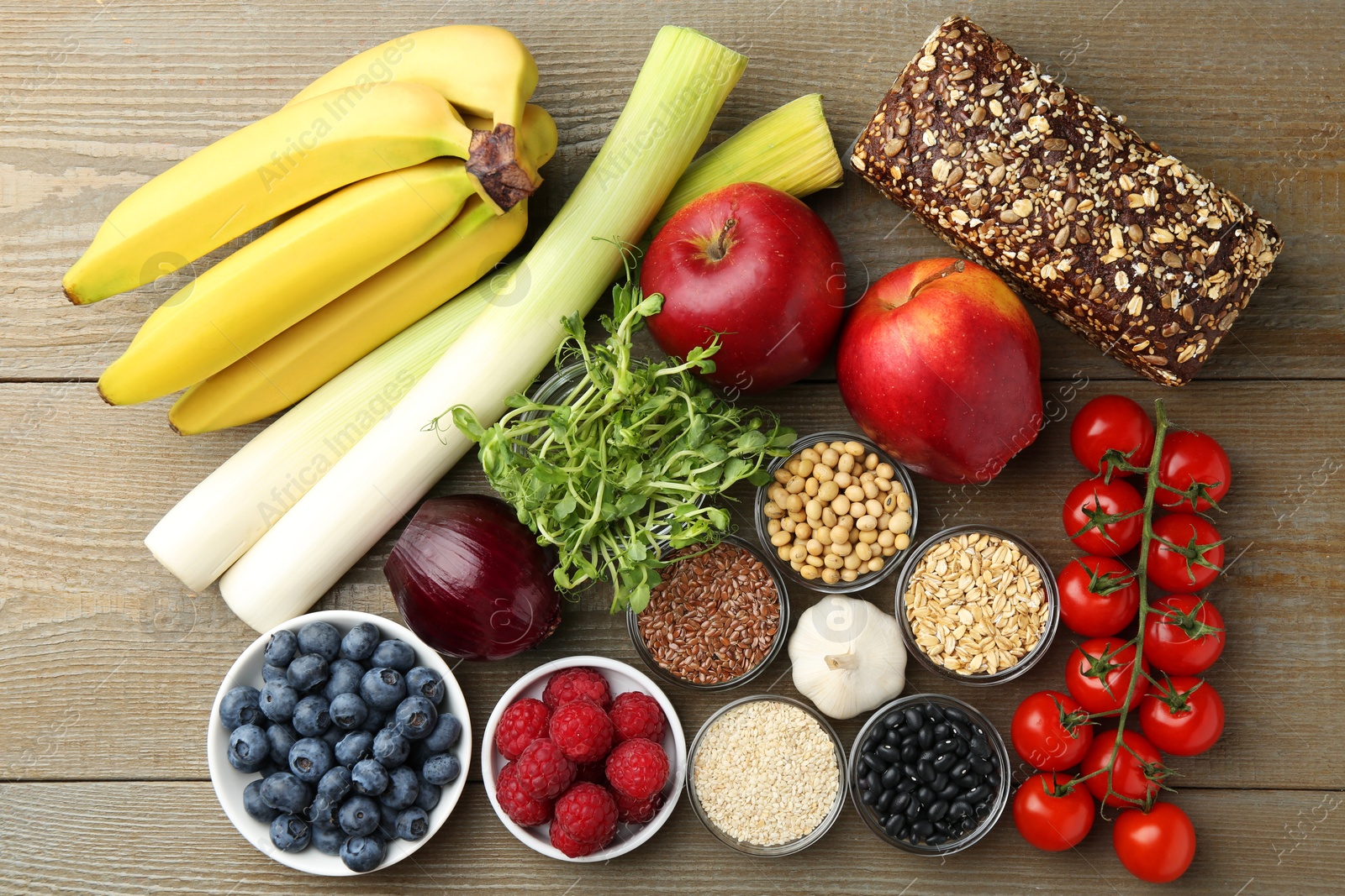 Photo of Different fresh products on wooden table, flat lay. Source of prebiotics