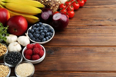 Photo of Different fresh products on wooden table, space for text. Source of prebiotics