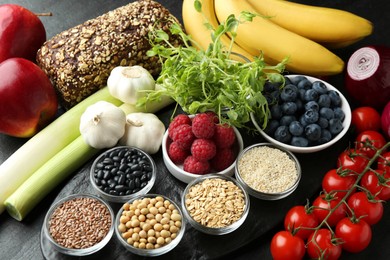 Photo of Different fresh products on black table. Source of prebiotics