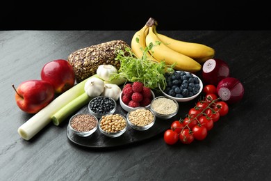 Photo of Different fresh products on black table. Source of prebiotics