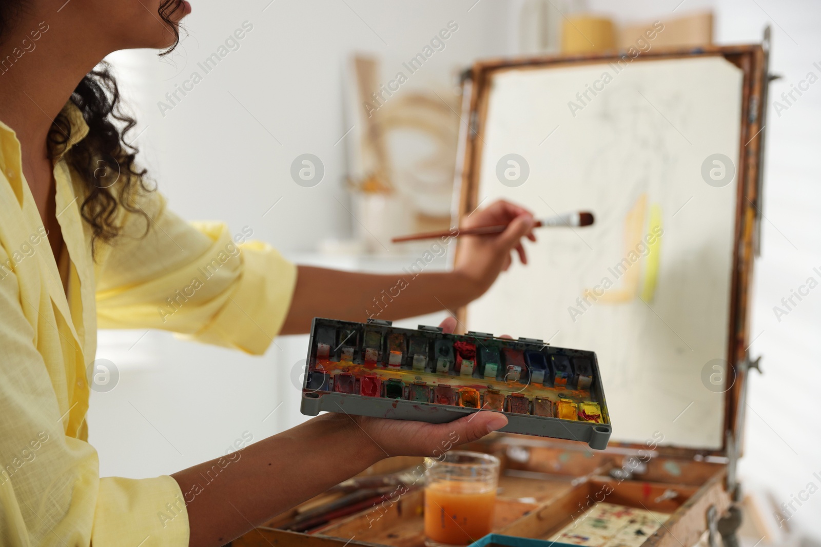 Photo of Woman drawing picture with paint in studio, closeup