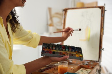 Woman drawing picture with paint in studio, closeup