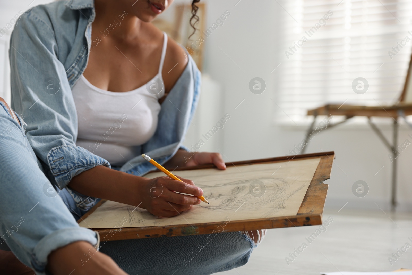 Photo of Woman drawing picture with pencil in studio, closeup