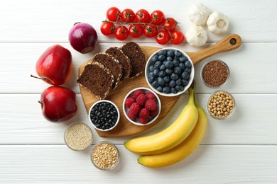 Photo of Different fresh products on white wooden table, flat lay. Source of prebiotics