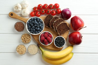 Different fresh products on white wooden table, flat lay. Source of prebiotics