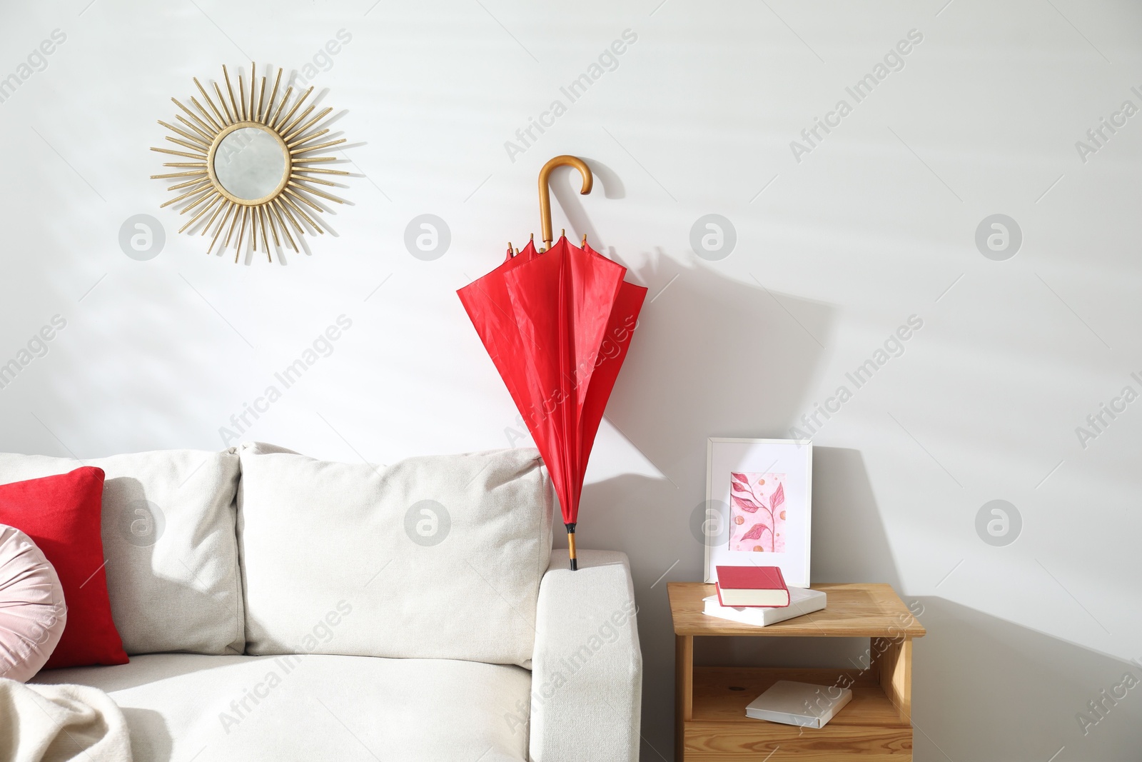 Photo of Red umbrella drying on sofa at home