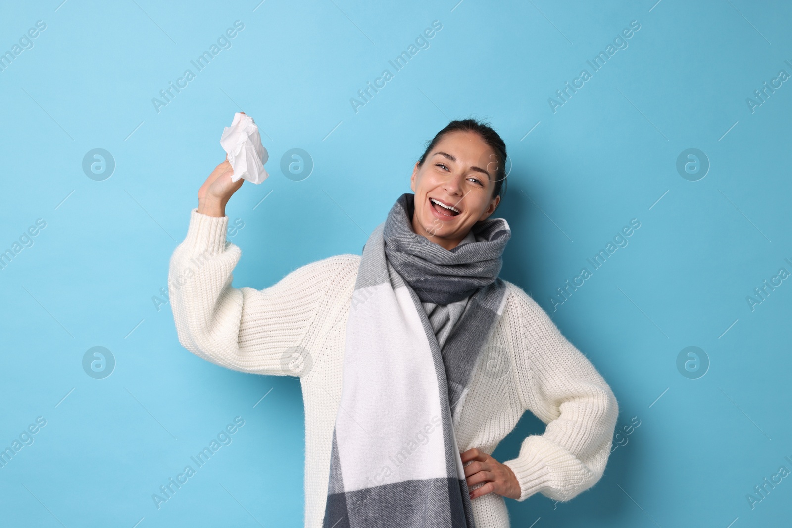 Photo of Smiling woman with tissue on light blue background