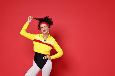 Aerobics. Happy woman in sportswear on red background, space for text