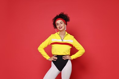 Photo of Aerobics. Happy woman in sportswear on red background