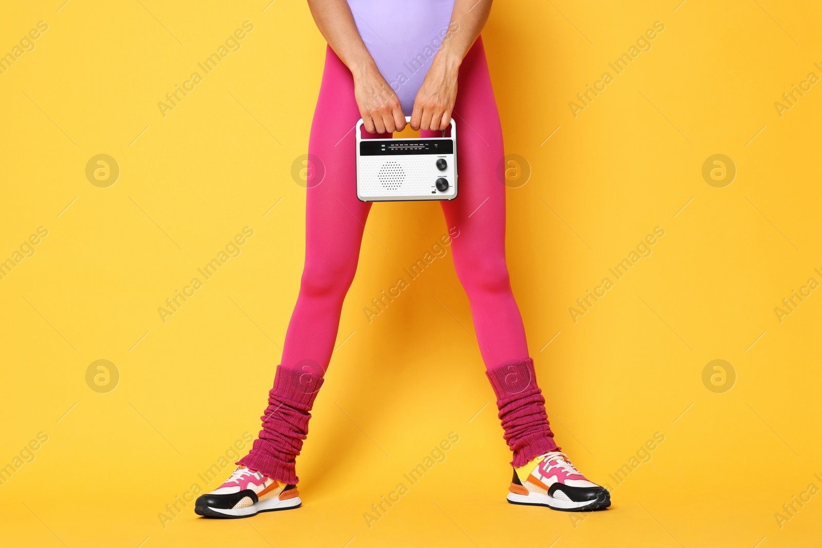 Photo of Aerobics. Woman with radio receiver on orange background, closeup