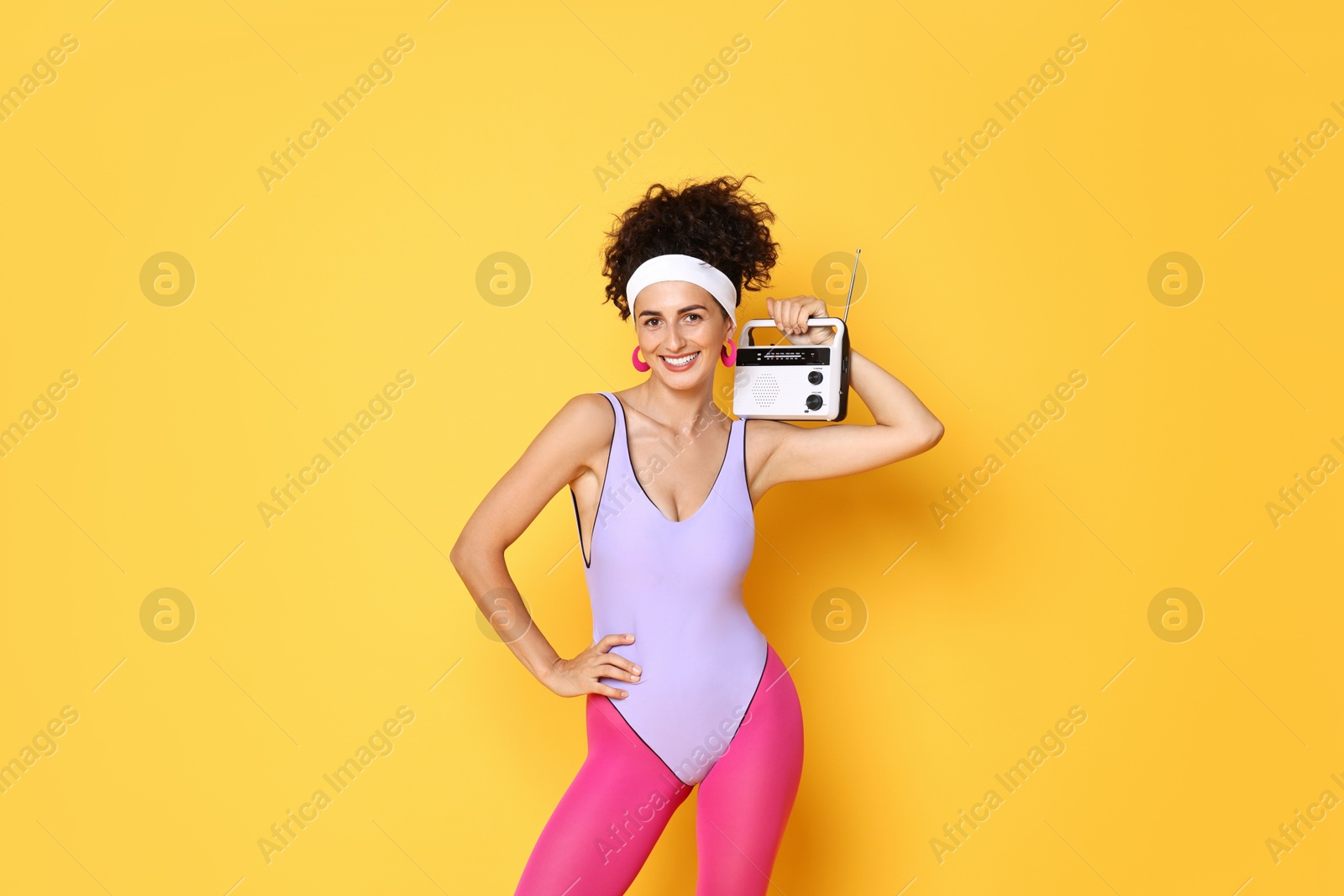 Photo of Aerobics. Woman with radio receiver on orange background