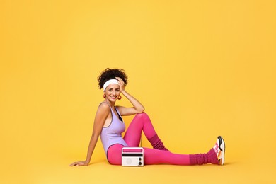 Photo of Aerobics. Woman with radio receiver on orange background