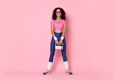 Photo of Aerobics. Woman with radio receiver on pink background