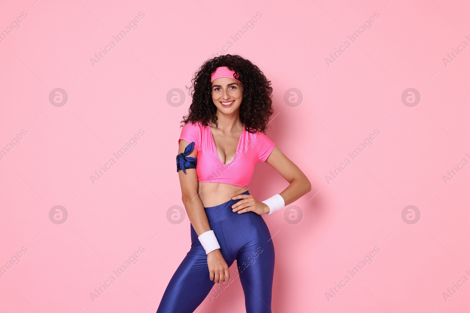 Photo of Aerobics. Happy woman in sportswear on pink background