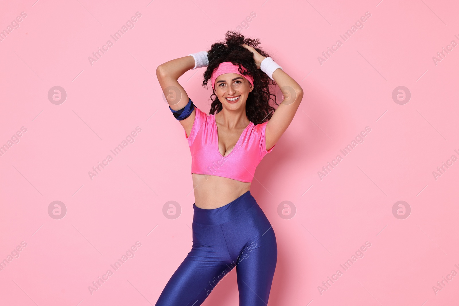 Photo of Aerobics. Happy woman in sportswear on pink background