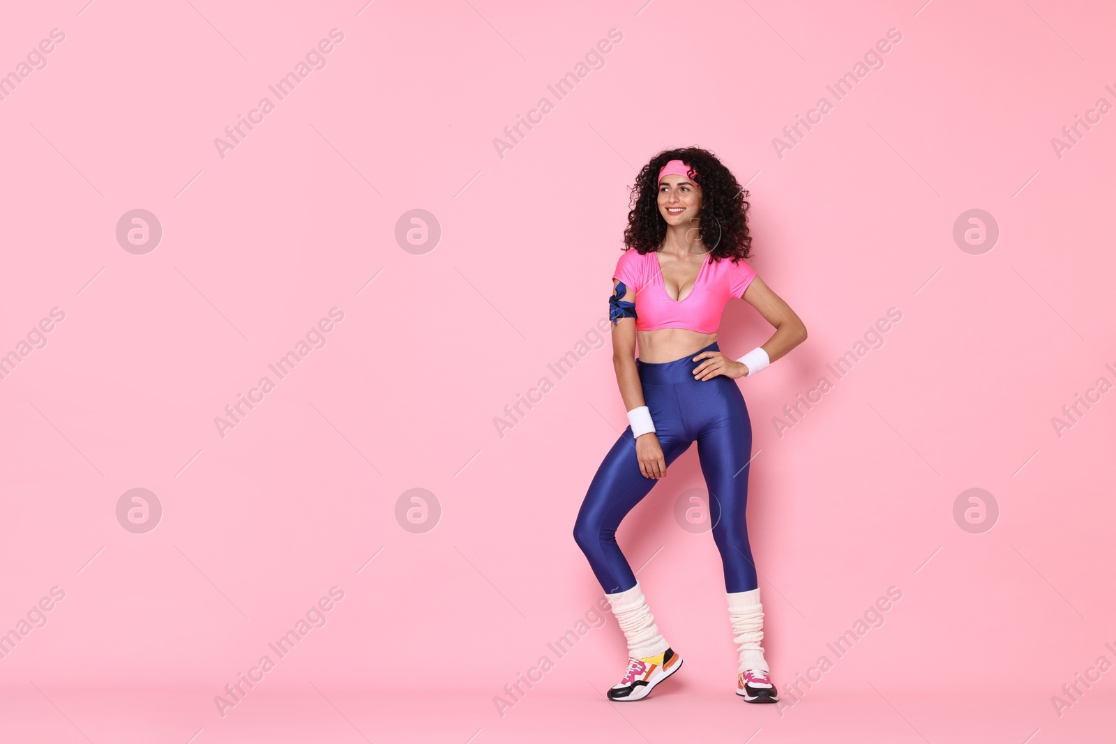 Photo of Aerobics. Happy woman in sportswear on pink background