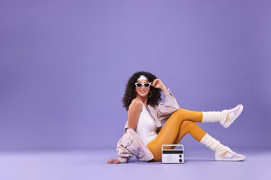 Aerobics. Woman with radio receiver on purple background