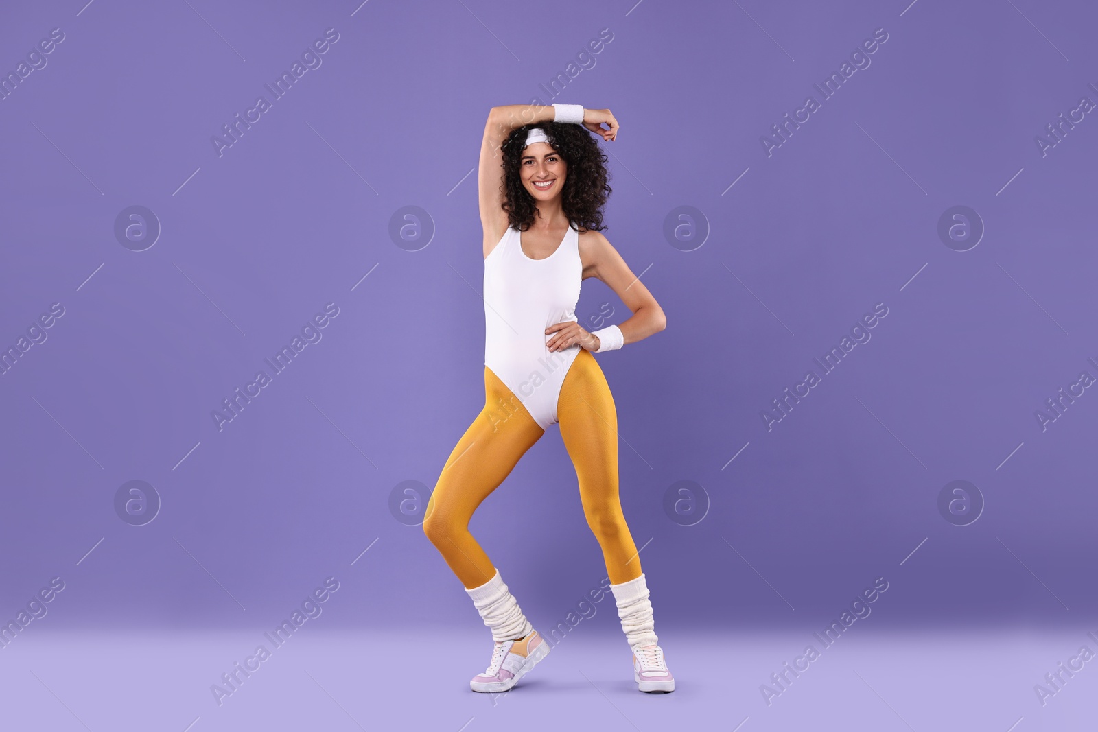 Photo of Happy woman in sportswear on purple background