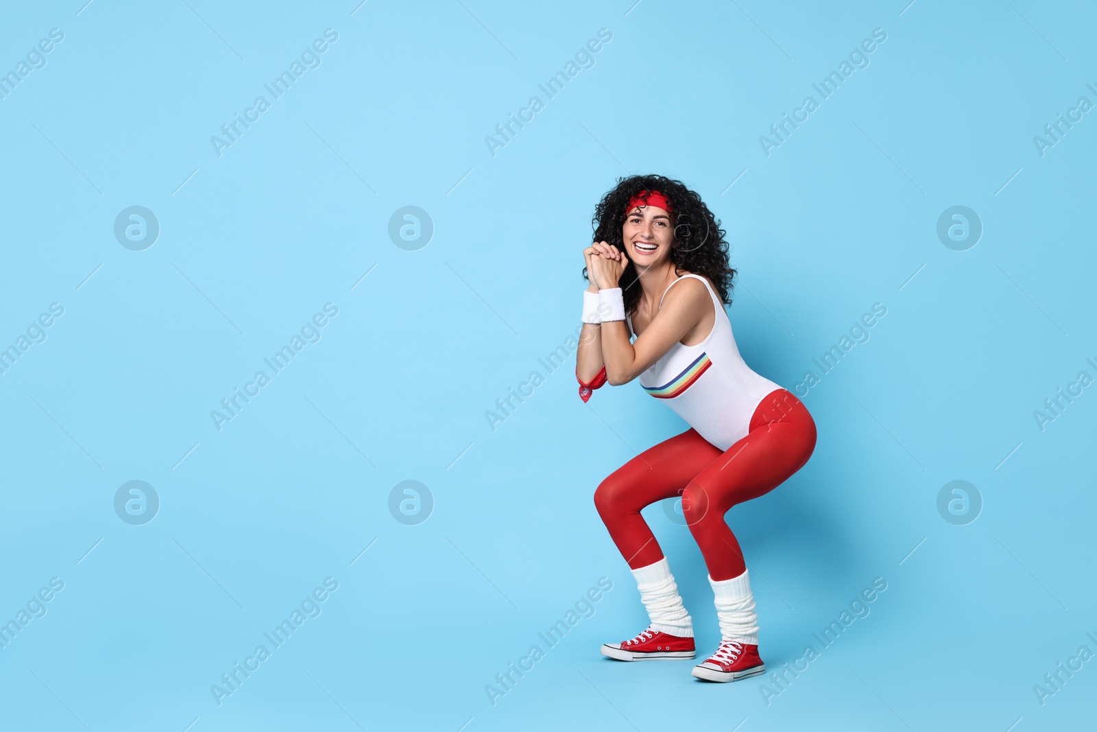 Photo of Woman doing aerobic exercise on light blue background, space for text