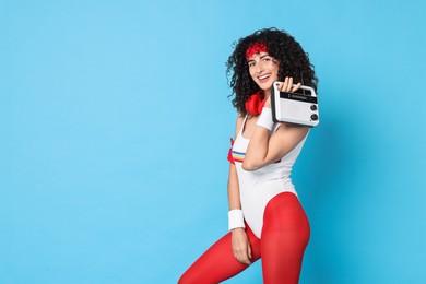 Aerobics. Happy woman with radio receiver on light blue background, space for text