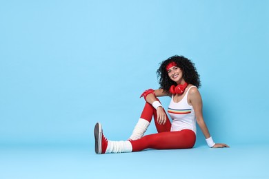 Aerobics. Happy woman with headphones on light blue background