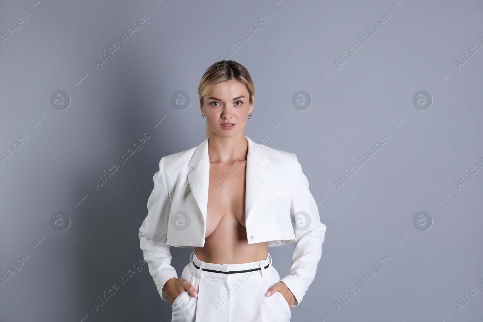 Photo of Beautiful woman in stylish white suit on grey background