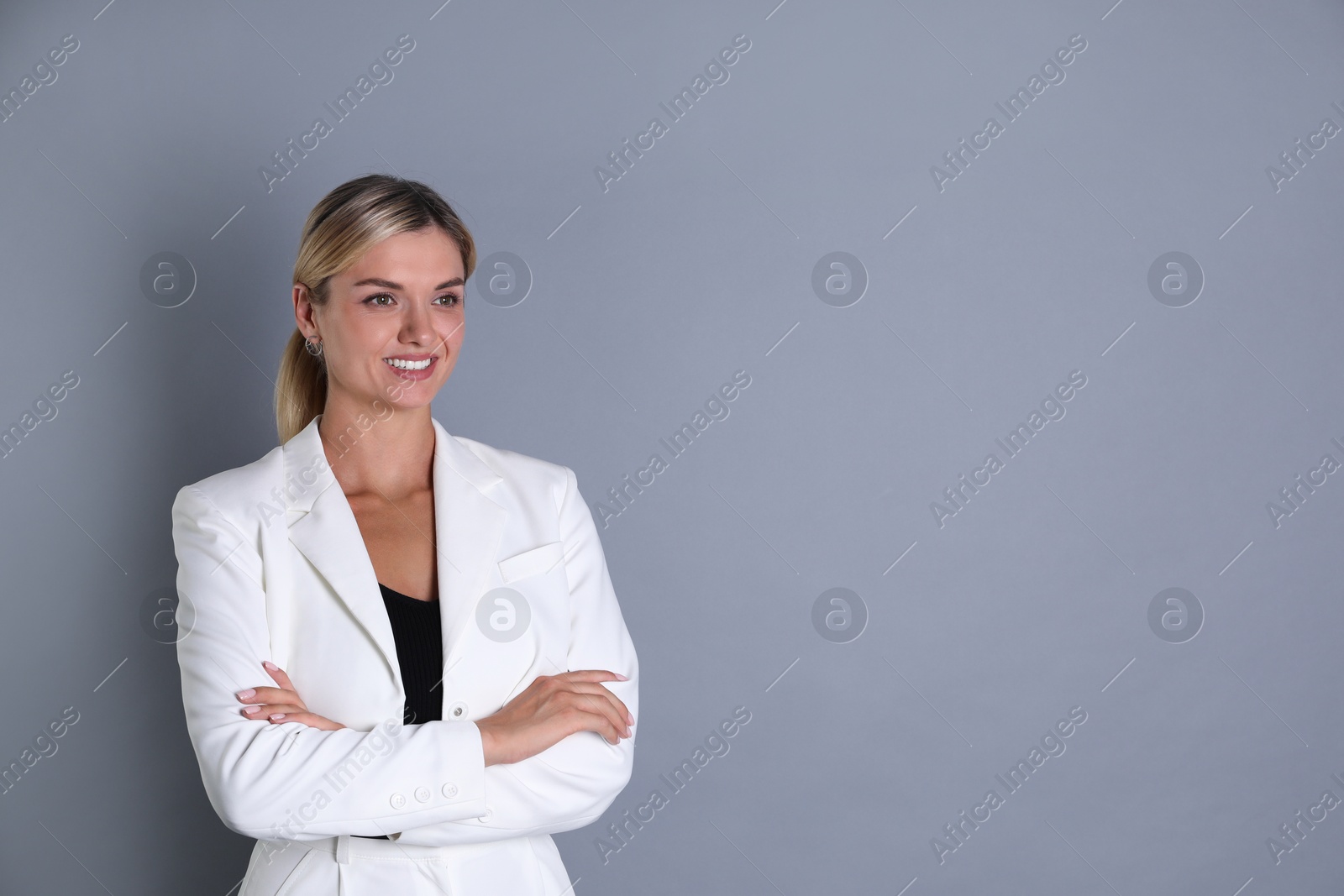 Photo of Beautiful woman in stylish white suit on grey background, space for text