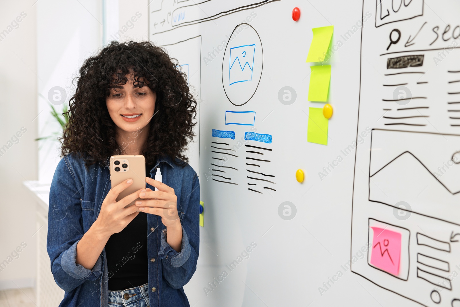 Photo of Developing UI design. Woman planning website wireframe on whiteboard indoors