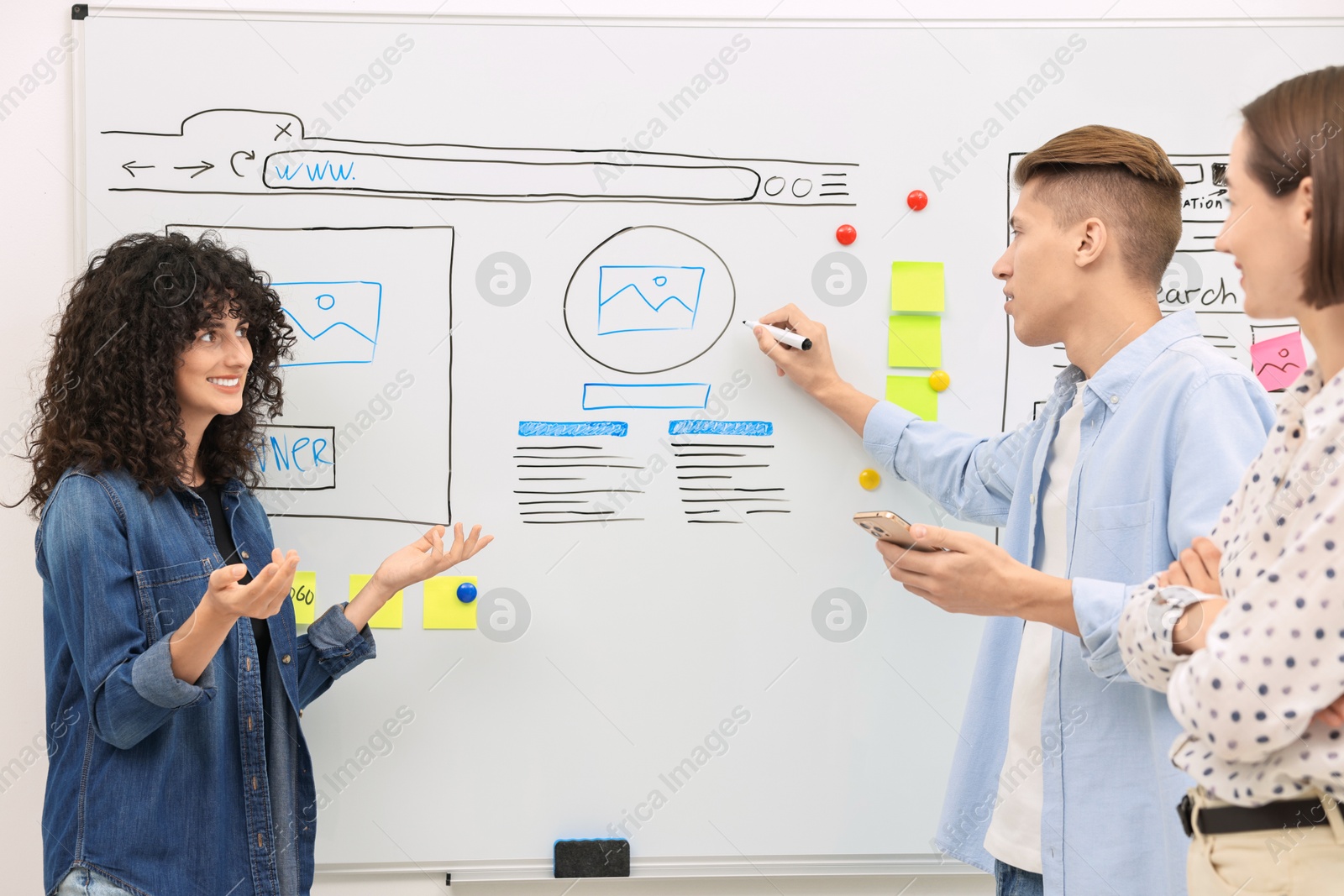 Photo of Developing UI design. People drawing website wireframe on whiteboard indoors