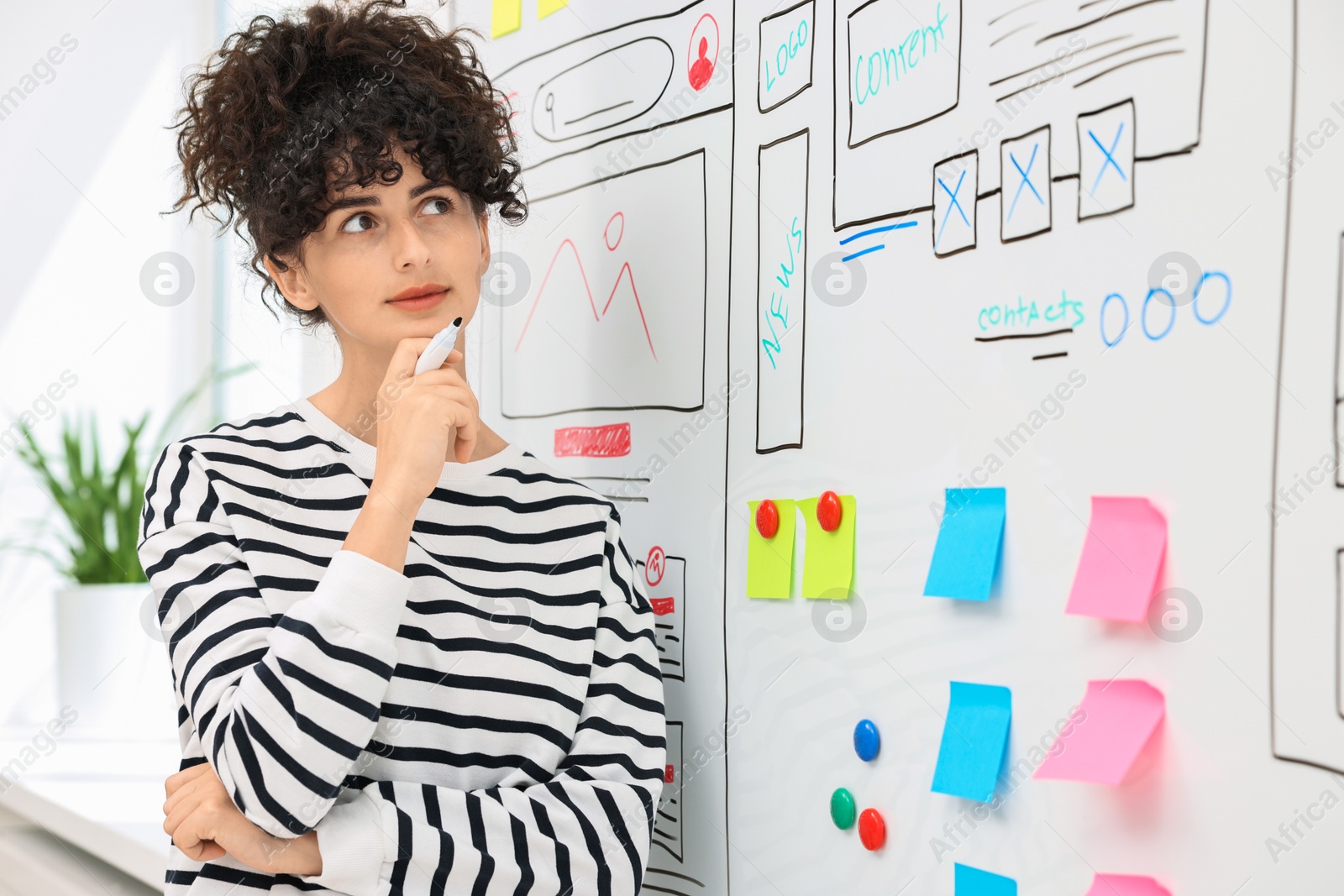 Photo of Developing UI design. Woman drawing website wireframe on whiteboard indoors