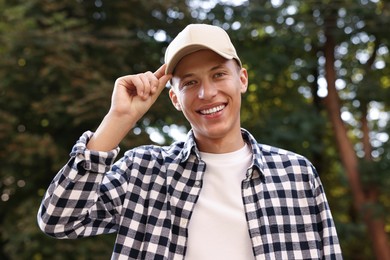 Photo of Portrait of smiling man in baseball cap outdoors