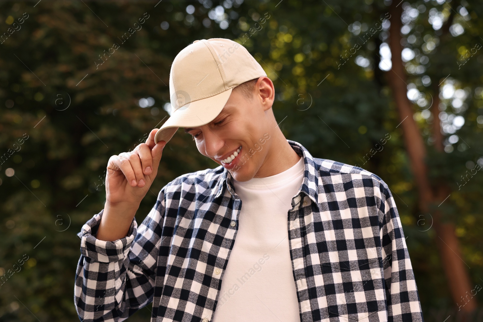 Photo of Portrait of smiling man in baseball cap outdoors