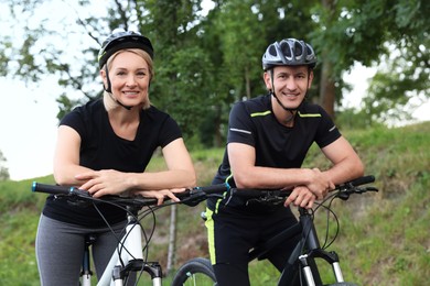 Happy couple with bicycles in park, low angle view