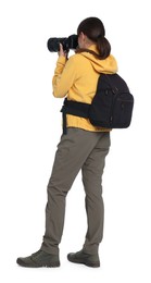 Photographer with backpack and camera taking picture on white background